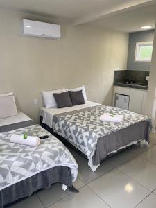 um quarto com duas camas e uma cozinha em Hospedagem Pierina em Gramado