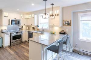 a kitchen with white cabinets and a large island at Captain Dan's Cozy in Saint Andrews