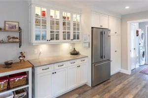 a kitchen with white cabinets and a stainless steel refrigerator at Captain Dan's Cozy in Saint Andrews