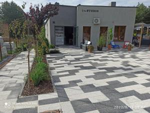 une terrasse en pierre avec un arbre en face d'un bâtiment dans l'établissement 3-Studio, à Poznań