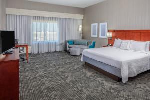 a large hotel room with a bed and a couch at Courtyard by Marriott Houston Medical Center/NRG Park in Houston