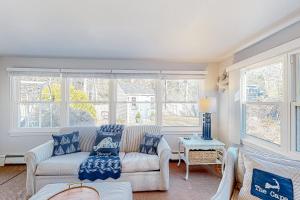 sala de estar con sofá, sillas y ventanas en Little River Manor, en Cotuit