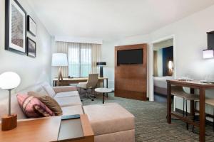 a hotel room with a couch and a table at Residence Inn by Marriott Sarasota Bradenton in Sarasota