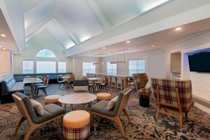 Habitación grande con mesas, sillas y TV. en Residence Inn by Marriott Sarasota Bradenton, en Sarasota