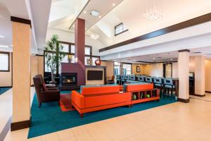 a lobby with orange furniture and a fireplace at Residence Inn by Marriott Fargo in Fargo