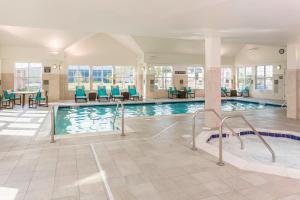 una piscina con sillas azules y una mesa en Residence Inn by Marriott Fargo, en Fargo