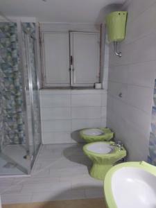 baño con 2 aseos verdes y lavamanos en Casa SoleMare a pochi passi dalla spiaggia di Terracina, en Terracina