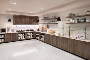 a large kitchen with wooden cabinets and shelves at Residence Inn by Marriott San Marcos in San Marcos