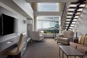 a living room with a couch and a tv at Niagara Falls Marriott Fallsview Hotel & Spa in Niagara Falls