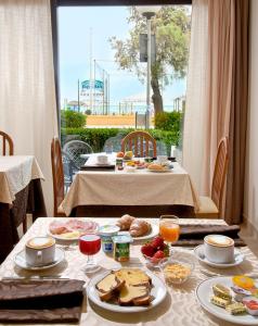 a table with breakfast food on it with a window at Hotel Argentina in Senigallia