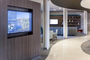 a flat screen tv on a wall in a lobby at Courtyard by Marriott Santa Clarita Valencia in Valencia