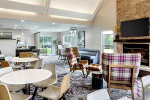 a lobby with tables and chairs and a fireplace at Residence Inn Denver North/Westminster in Westminster