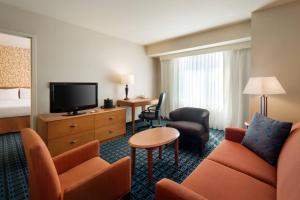 Habitación de hotel con sofá y TV en Fairfield Inn Sacramento Cal Expo, en Sacramento