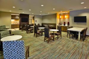 a waiting room with tables and chairs and a tv at Residence Inn by Marriott Chicago Wilmette/Skokie in Wilmette