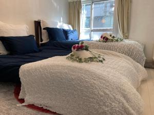 Duas camas com flores num quarto em BEST LOCATED SHINJUKU CENTRAL Full-Furnished APARTMENT 3minWalk to Station2 em Tóquio