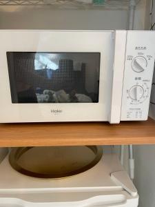 a white microwave sitting on top of a table at BEST LOCATED SHINJUKU CENTRAL Full-Furnished APARTMENT 3minWalk to Station2 in Tokyo