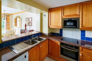 a kitchen with wooden cabinets and a sink at Marriott's Village d'Ile-de-France in Bailly-Romainvilliers