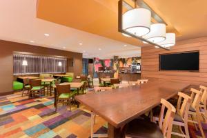 Fairfield Inn & Suites by Marriott Pittsburgh Airport/Robinson Township في روبنسون تاونشيب: غرفة طعام مع طاولة وكراسي خشبية كبيرة