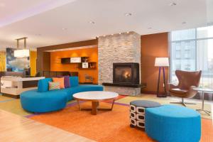 Fairfield Inn & Suites by Marriott Pittsburgh Airport/Robinson Township في روبنسون تاونشيب: غرفة معيشة مع أثاث أزرق ومدفأة