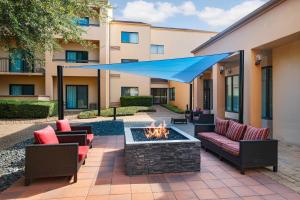 une terrasse avec un foyer extérieur et un auvent bleu dans l'établissement Courtyard by Marriott San Antonio Medical Center, à San Antonio