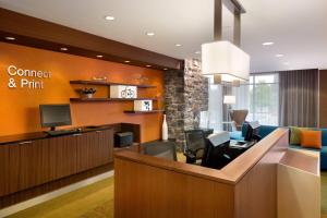 a lobby with a waiting room with a computer and a desk at Fairfield Inn & Suites by Marriott Lancaster East at The Outlets in Lancaster