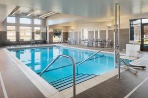 een groot zwembad met stoelen en tafels bij Residence Inn by Marriott Minneapolis St. Paul/Eagan in Eagan