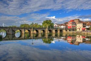 a bridge over a body of water with buildings at Casa Valadim in Chaves