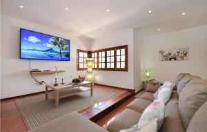 een woonkamer met een bank en een tv aan de muur bij Lovely Home In Cercado De Espino With Swimming Pool in Los Palmitos