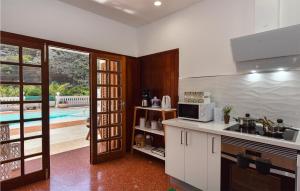 een keuken met een wastafel en een magnetron bij Lovely Home In Cercado De Espino With Swimming Pool in Los Palmitos