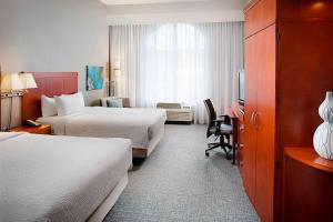 サンアントニオにあるCourtyard by Marriott San Antonio SeaWorld®/Westover Hillsのベッド2台とテレビが備わるホテルルームです。