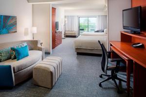 a hotel room with a bedroom with a desk and a bed at Courtyard by Marriott San Antonio SeaWorld®/Westover Hills in San Antonio
