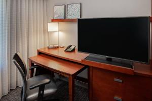 a hotel room with a desk with a flat screen tv at Courtyard by Marriott San Antonio SeaWorld®/Westover Hills in San Antonio