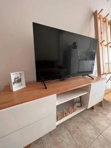 a large flat screen tv sitting on top of a cabinet at Luminoso depto 2 o 3 personas Zona residencial in Morón