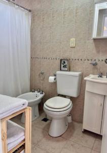 ein Badezimmer mit einem weißen WC und einem Waschbecken in der Unterkunft Luminoso depto 2 o 3 personas Zona residencial in Morón