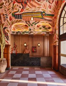 a man standing in a room with a painting on the ceiling at Downtown Los Angeles Proper Hotel, a Member of Design Hotels in Los Angeles