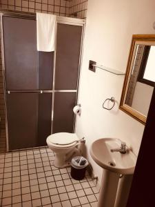 a bathroom with a shower and a toilet and a sink at Porto Rei Residence Hotel in Rio Grande