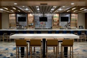 un gran bar con sillas y una gran mesa blanca en Delta Hotels by Marriott Utica en Utica