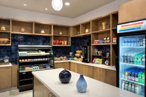 ユーティカにあるDelta Hotels by Marriott Uticaの冷蔵庫、棚(ドリンク付)が備わる広い客室です。