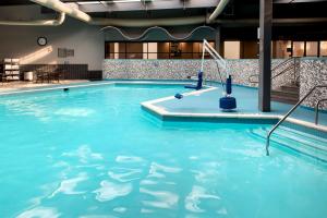 - une piscine d'eau bleue dans un bâtiment dans l'établissement Delta Hotels by Marriott Utica, à Utica