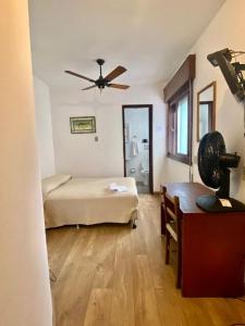 een slaapkamer met een bed en een plafondventilator bij Porto Rei Residence Hotel in Rio Grande +26 foto's