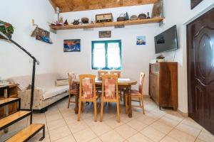 a kitchen and dining room with a table and chairs at Secluded fisherman's cottage Cove Soline, Pasman - 8222 in Kraj