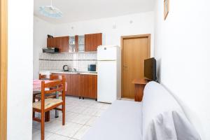 małą kuchnię ze stołem i lodówką w obiekcie Apartments by the sea Pasman - 8221 w mieście Pašman
