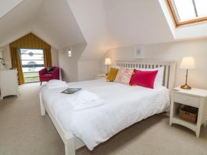 a bedroom with a large white bed with colorful pillows at Atlantic Reach in Bude