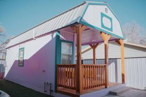 a house with a gambrel roof with a deck at Agave Tiny House at Cactus Flower-HOT TUB-Pet Friendly-No Pet Fees! in Albuquerque