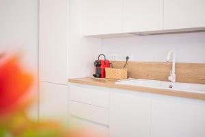 a kitchen with a sink and a red appliance at Mizzica! - Holiday Home in Taormina