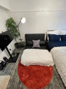 sala de estar con 2 camas y alfombra roja en BEST LOCATED SHINJUKU CENTRAL Full-Furnished APARTMENT 3minWalk to Station2, en Tokio