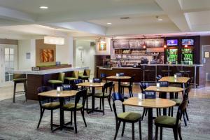 a restaurant with tables and chairs and a bar at Courtyard by Marriott Stockton in Stockton