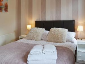 a bedroom with a bed with towels on it at 4 Eldin Hall Cottages in Cayton