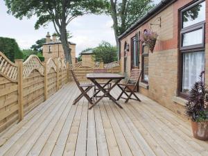 a wooden deck with a table and chairs on it at 4 Eldin Hall Cottages in Cayton
