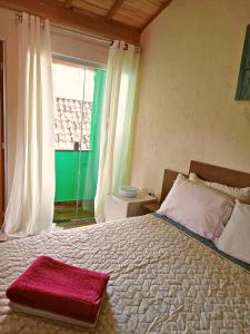 Un dormitorio con una cama grande con una toalla roja. en Suites em São Thomé das Letras, en São Thomé das Letras